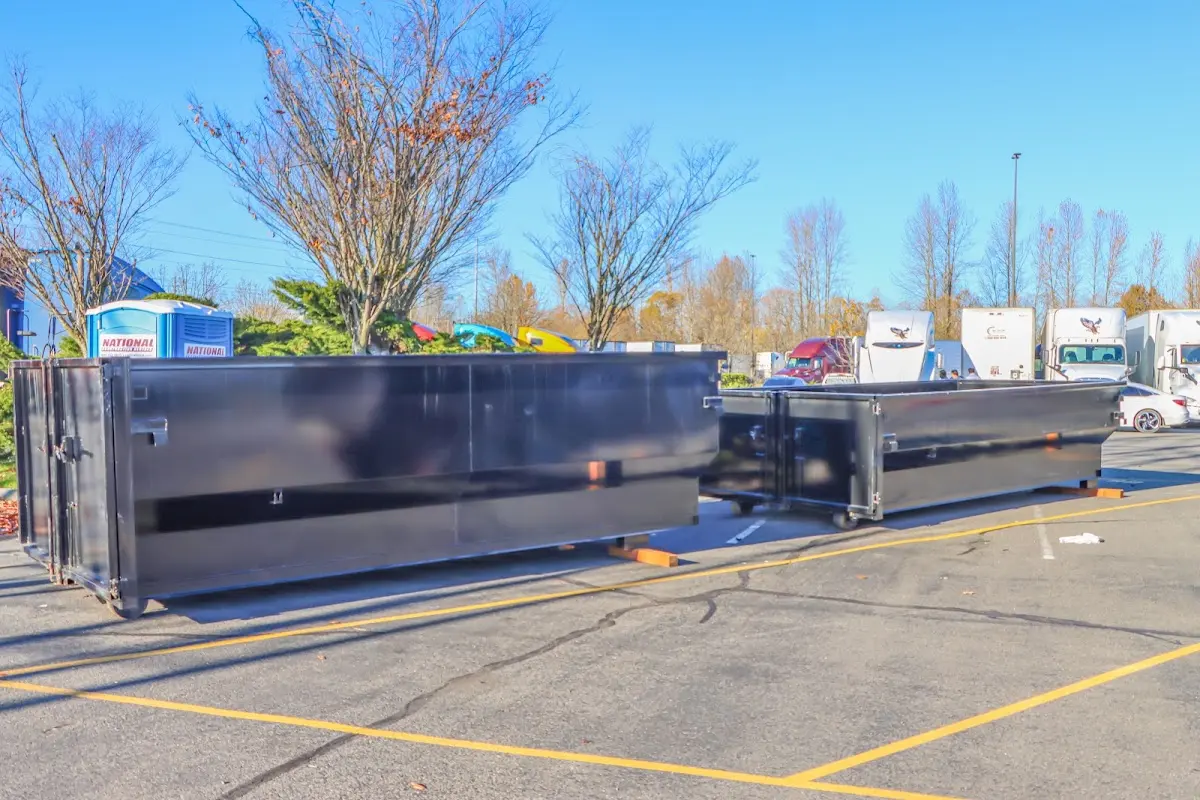 Professional dumpster rental service with roll-off container on residential driveway in Cranston